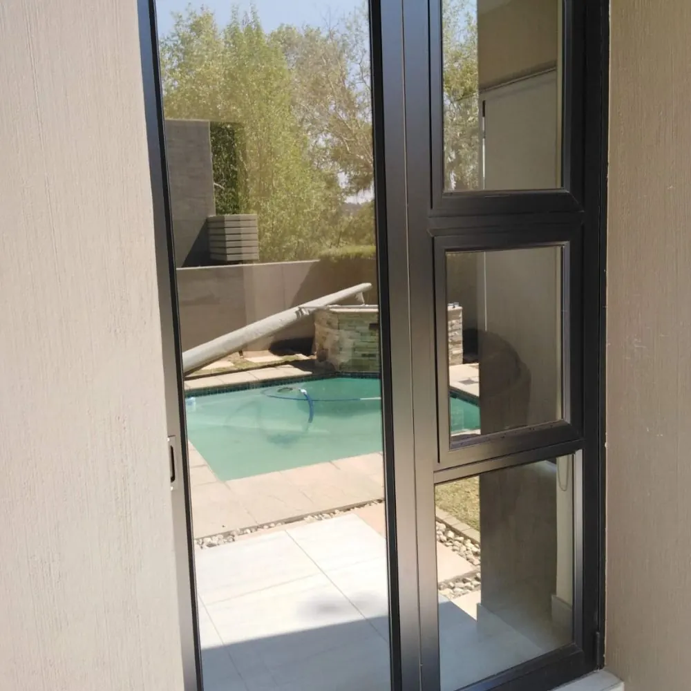 Frameless aluminium door overlooking a pool patio