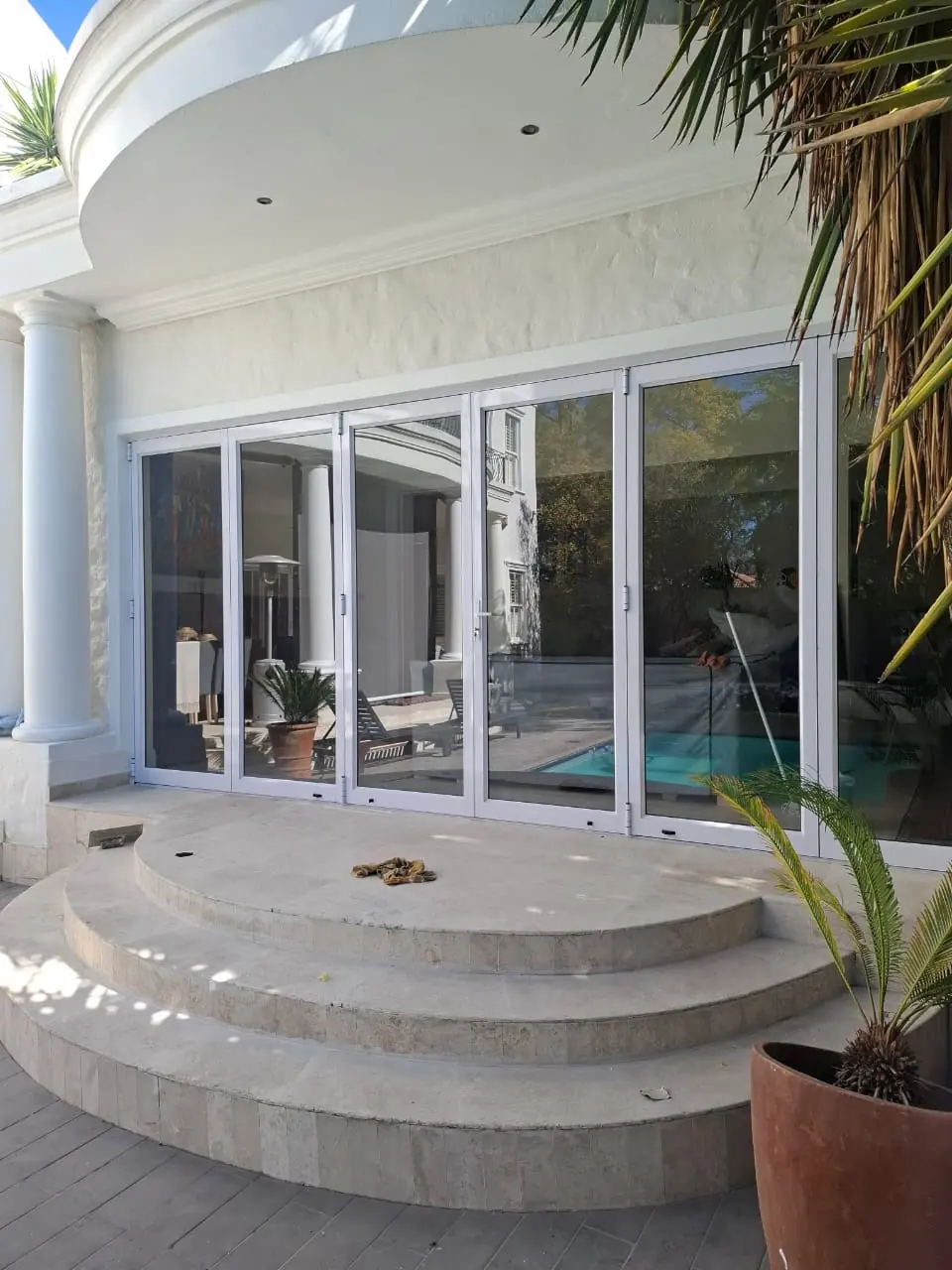 Stacking aluminium doors opening a patio onto a pool area